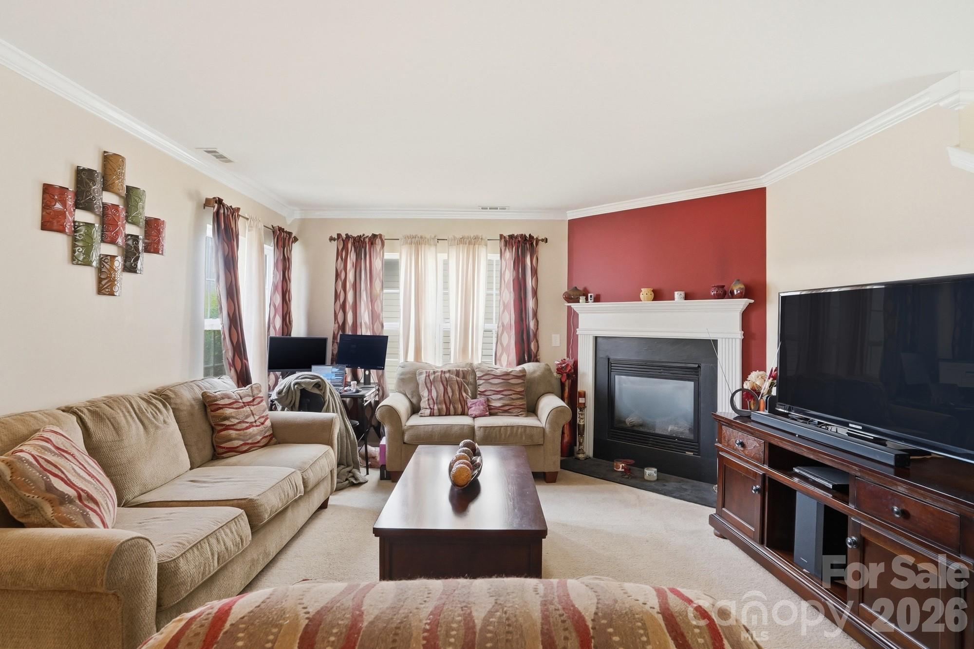 4404 Kiddle Lane Monroe, NC 28110 - Photo 10 of 48 a living room with furniture a flat screen tv and a fireplace