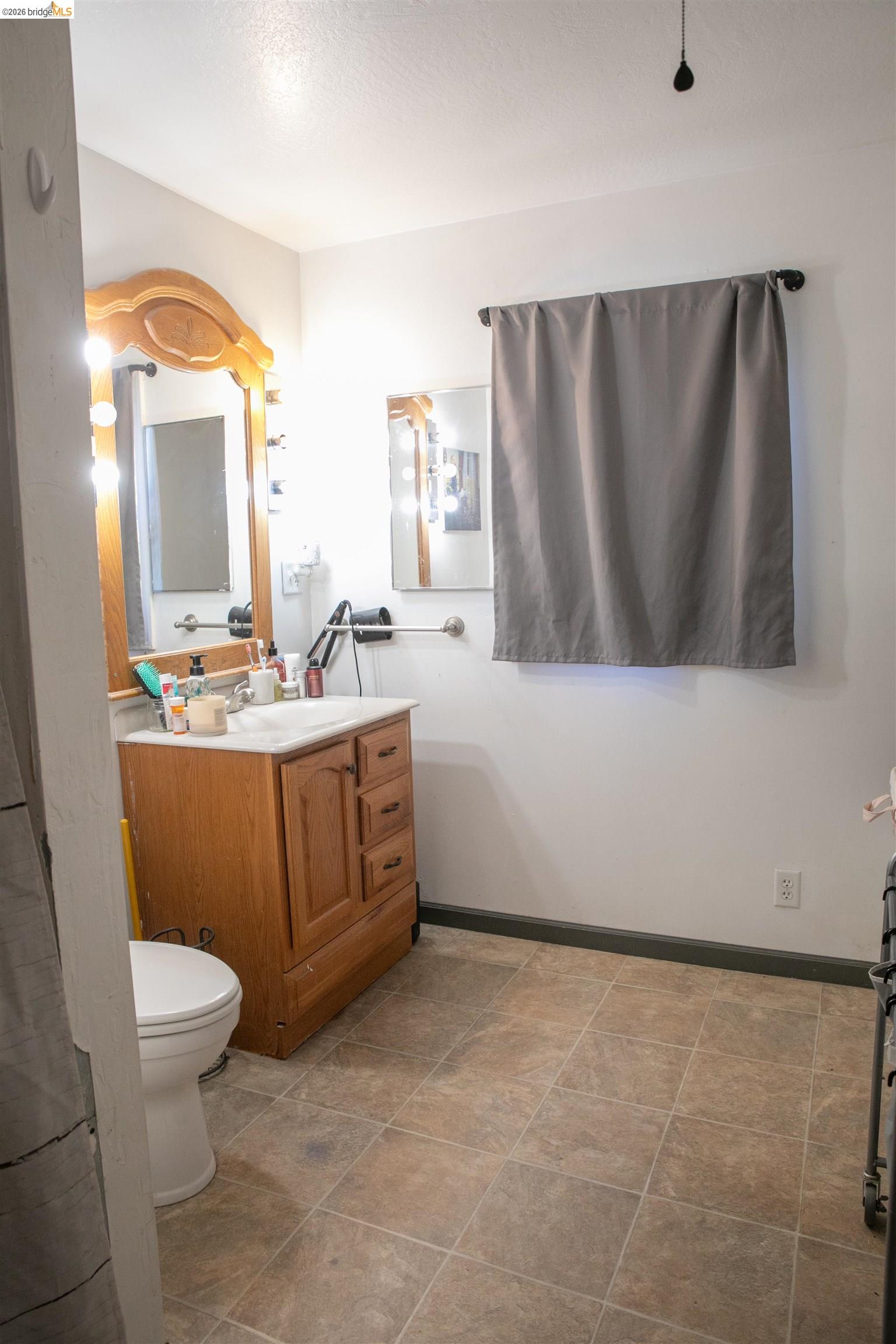 20982 Shaws Flat Road Sonora, CA 95370 - Photo 23 of 26 Bathroom featuring a wood-finish vanity with a white countertop, a white toilet, and square-tiled flooring