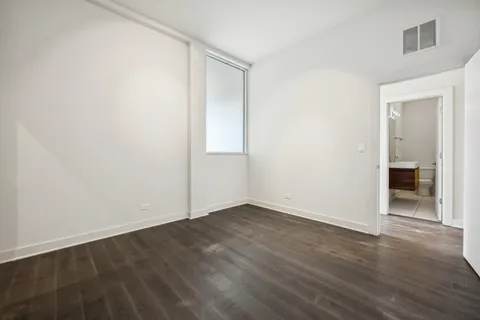 an empty room with wooden floor and closet