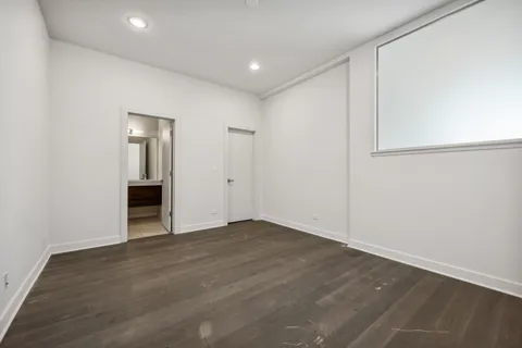 a view of an empty room with wooden floor and closet