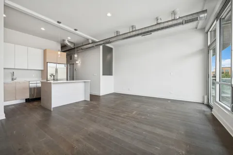 a view of a kitchen with a refrigerator and white cabinets
