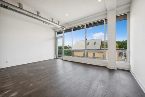 a view of a room with wooden floor and windows