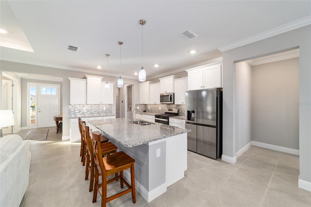 10318 Southwest 96th Loop Ocala, FL 34481 - Photo 23 of 67 a kitchen with refrigerator and chairs