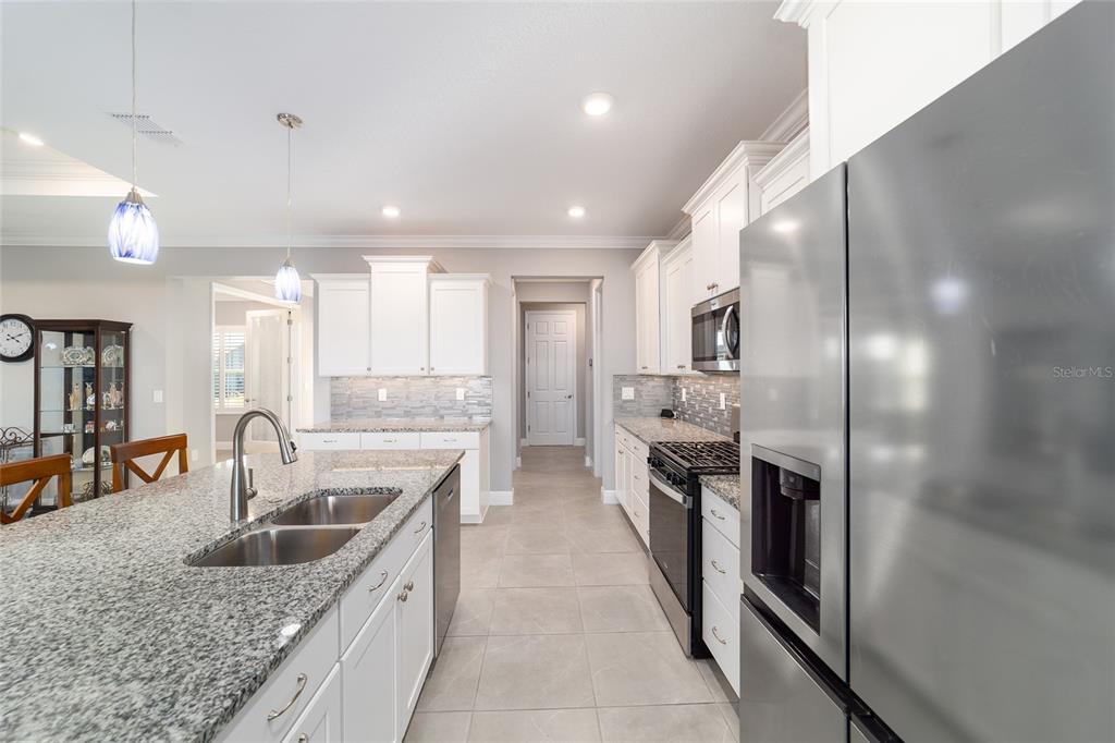 10318 Southwest 96th Loop Ocala, FL 34481 - Photo 25 of 67 a kitchen with stainless steel appliances granite countertop a sink and a refrigerator
