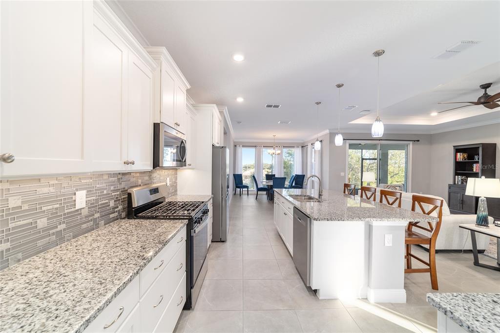 10318 Southwest 96th Loop Ocala, FL 34481 - Photo 27 of 67 a large kitchen with kitchen island a large counter top stainless steel appliances and cabinets