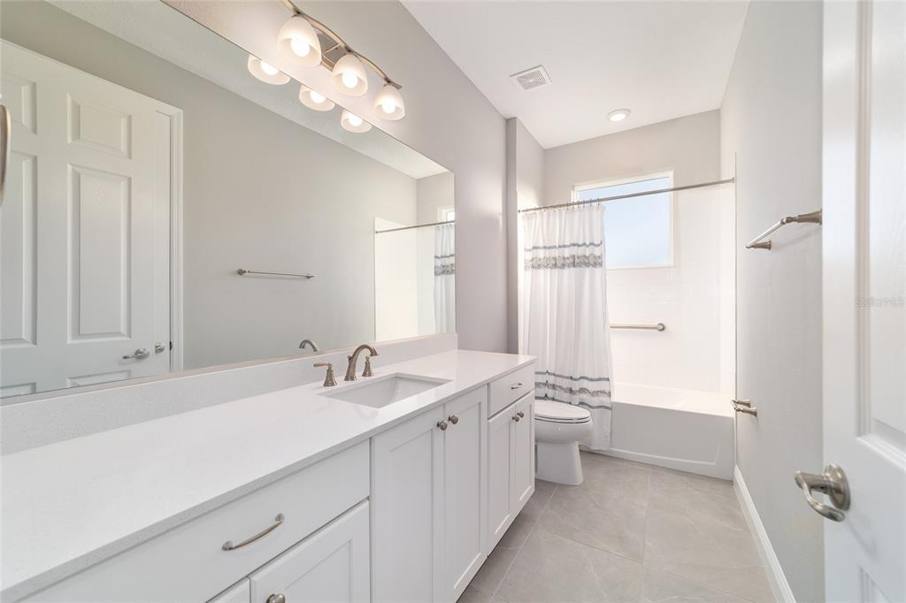 10318 Southwest 96th Loop Ocala, FL 34481 - Photo 47 of 67 a bathroom with a double vanity sink a mirror and a shower