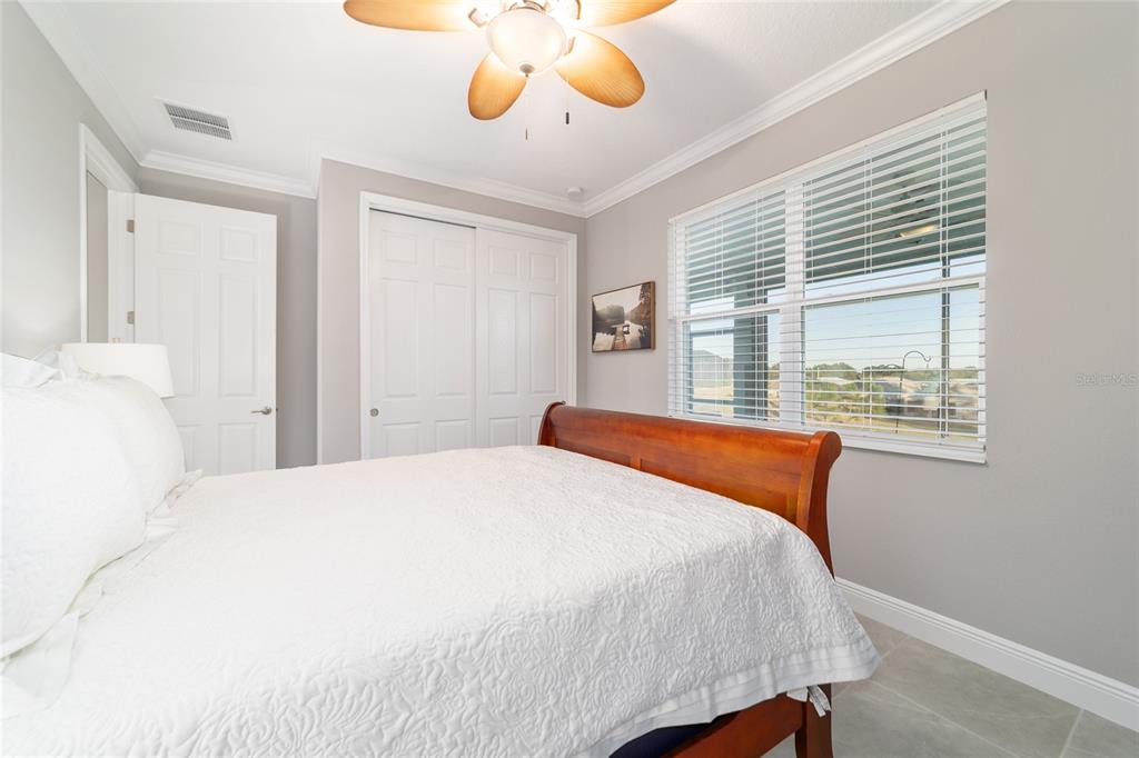 10318 Southwest 96th Loop Ocala, FL 34481 - Photo 50 of 67 a bedroom with a large bed and a chandelier