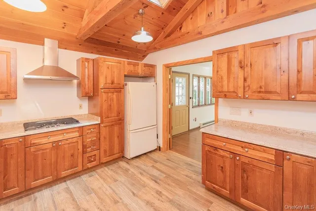 a kitchen with stainless steel appliances granite countertop a refrigerator a stove and a wooden floors