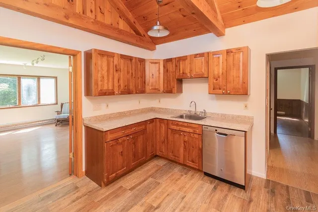 a kitchen with stainless steel appliances granite countertop a sink a stove cabinets and wooden floor