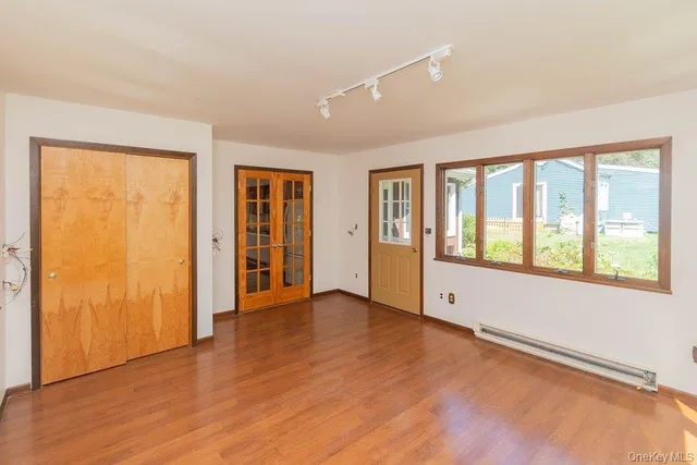an empty room with wooden floor and windows