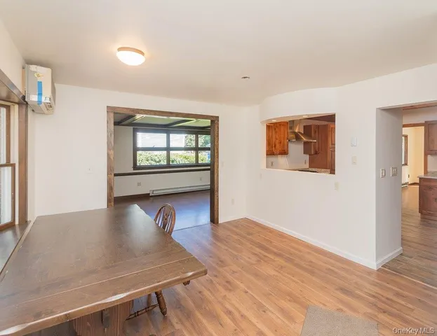 a view of an empty room with window and wooden floor