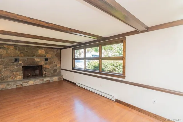 a view of an empty room with a fireplace and a window