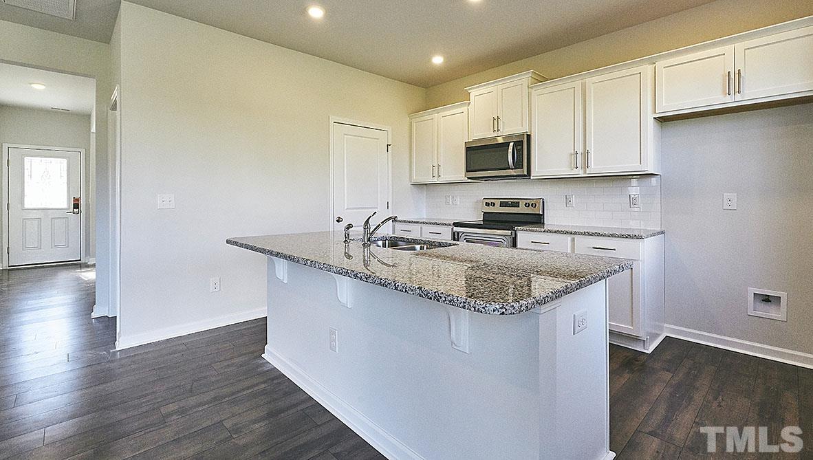 1023 Saddlebrook Drive Rocky Mount, NC 27804 - Photo 6 of 27 a kitchen with stainless steel appliances granite countertop a sink a stove a microwave a sink and dishwasher with wooden floor