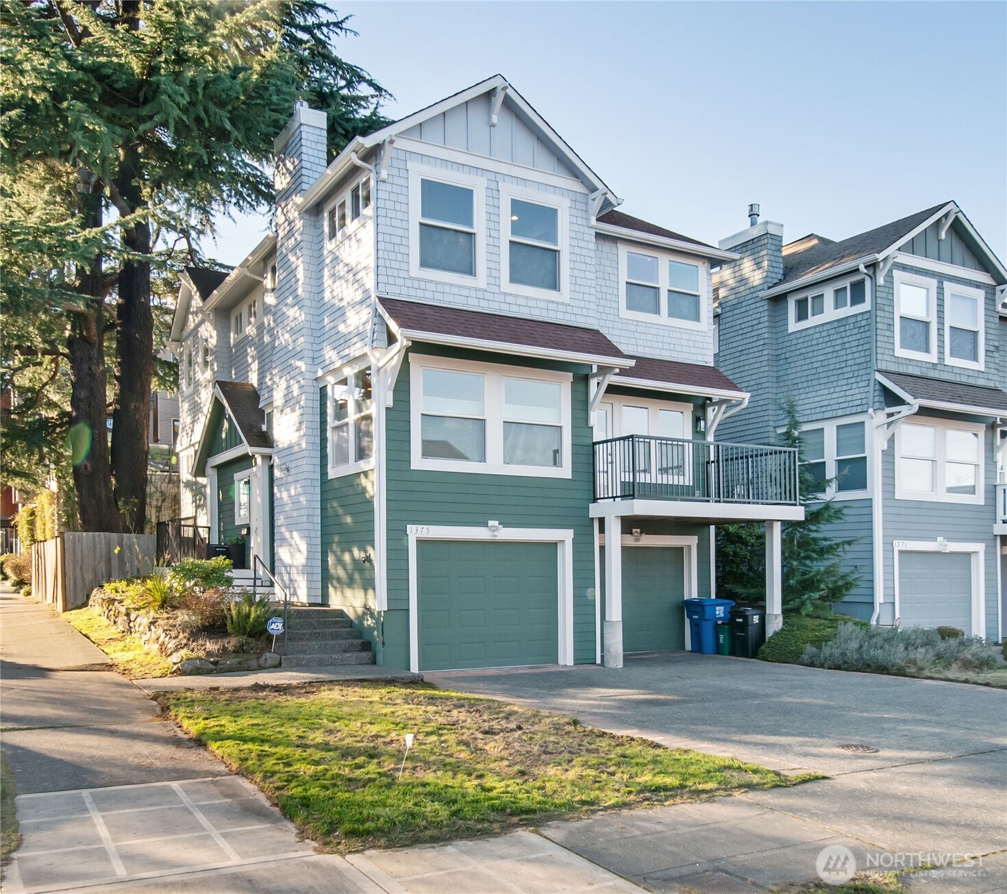 a front view of a house with garden and trees