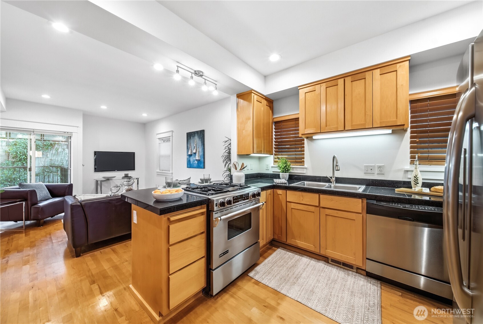1375 32nd Avenue South Seattle, WA 98144 - Photo 11 of 36 a kitchen with stainless steel appliances granite countertop a stove top oven a sink dishwasher a dining table and chairs with wooden floor