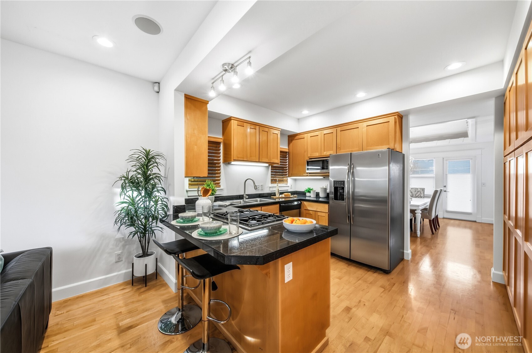 1375 32nd Avenue South Seattle, WA 98144 - Photo 12 of 36 a kitchen with stainless steel appliances granite countertop a refrigerator a stove a sink a dining table and chairs with wooden floor