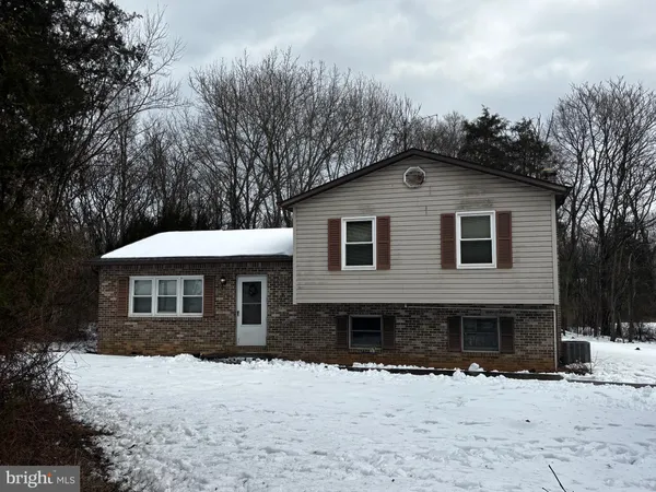 a front view of a house with a yard covered in snow