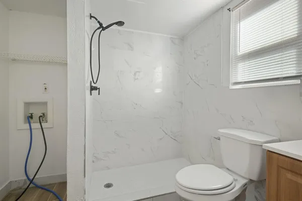 a white toilet sitting next to a bathroom shower