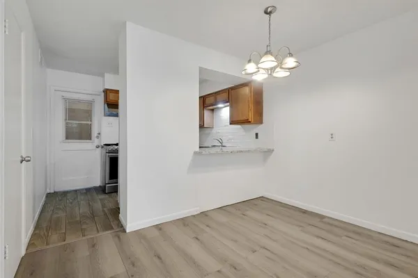 a view of a kitchen with wooden floor and a ceiling fan