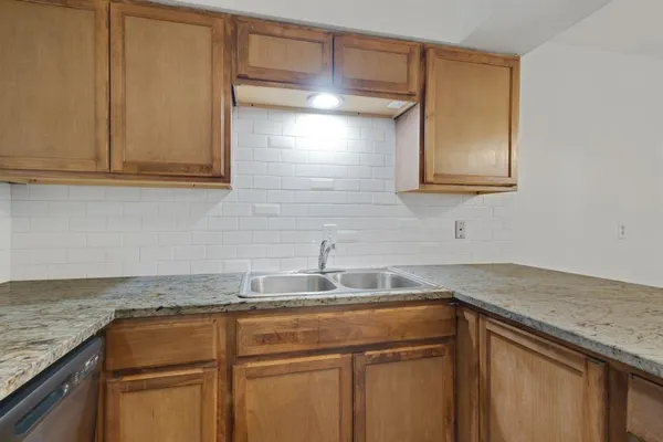 a kitchen with granite countertop cabinets sink and white stainless steel appliances