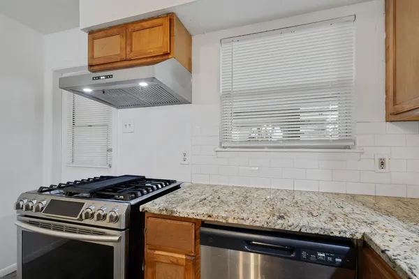 a kitchen with granite countertop a stove and a sink