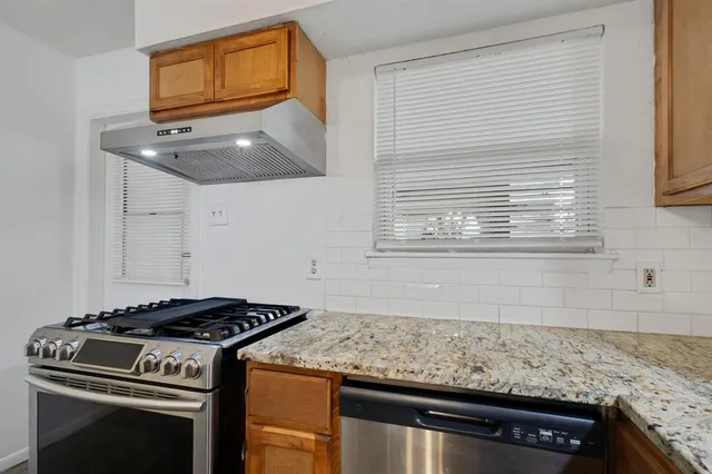 a kitchen with granite countertop a stove and a sink