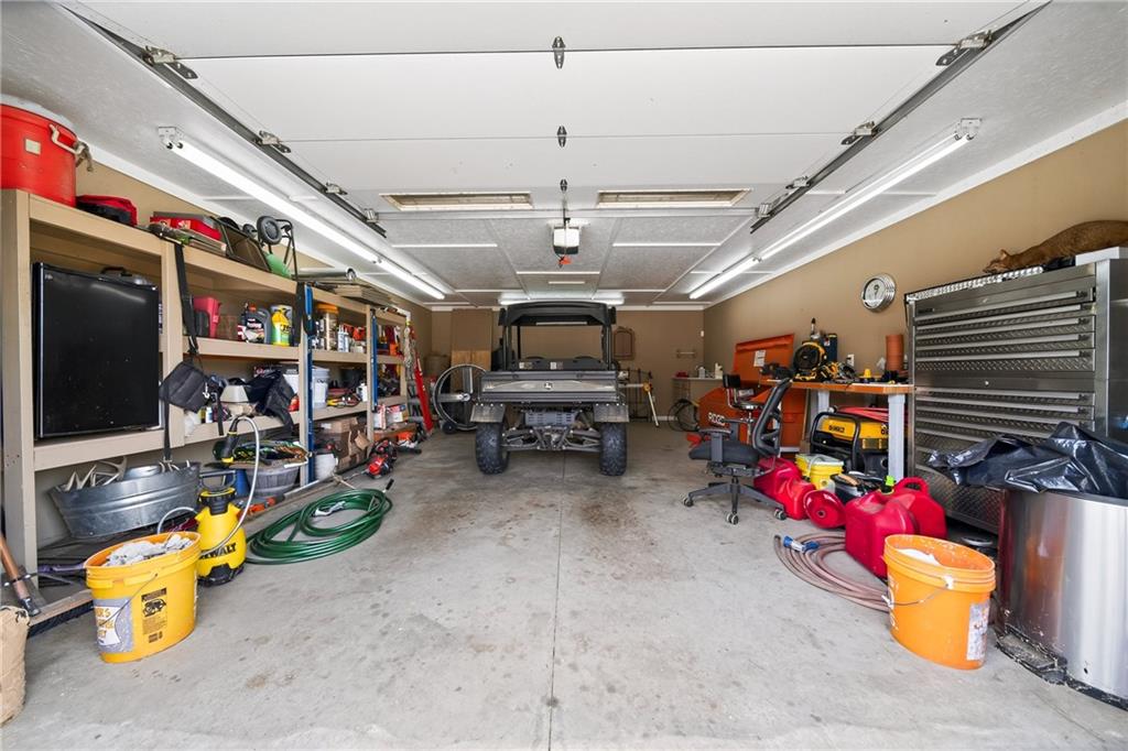 611 Padgetts Road Opelika, AL 36804 - Photo 42 of 64 Attached garage featuring a concrete floor, built-in shelving, and overhead fluorescent lighting