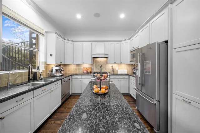 a kitchen with a refrigerator and a stove top oven