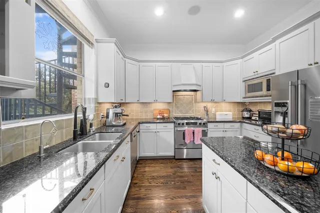 a kitchen with stainless steel appliances granite countertop a sink stove and refrigerator