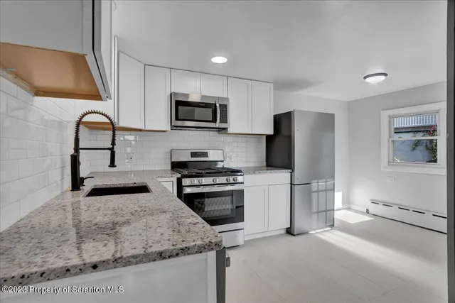 a kitchen with stainless steel appliances and a stove top oven