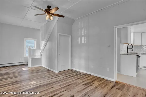a view of a livingroom with wooden floor and a ceiling fan
