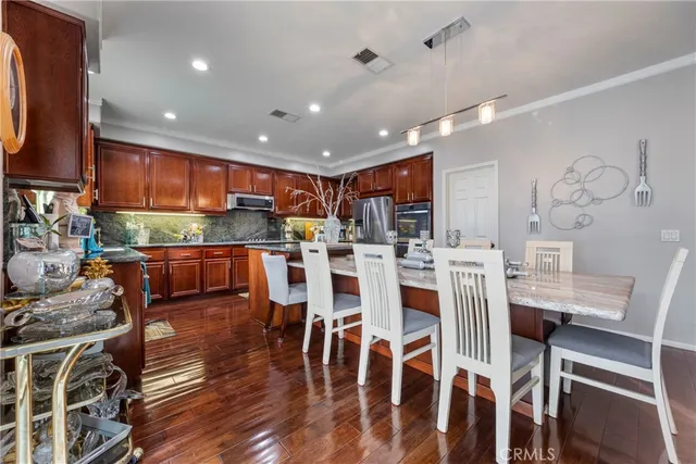 a kitchen with kitchen island granite countertop wooden cabinets a stove a sink and dishwasher