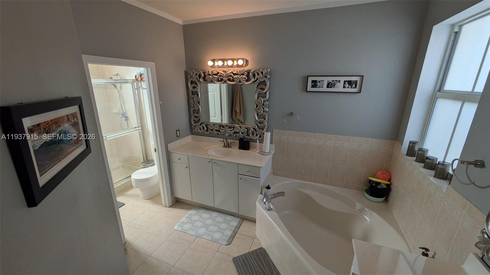 12293 Southwest 123rd Terrace Miami, FL 33186 - Photo 11 of 30 a bathroom with a sink a toilet a shower a mirror and vanity