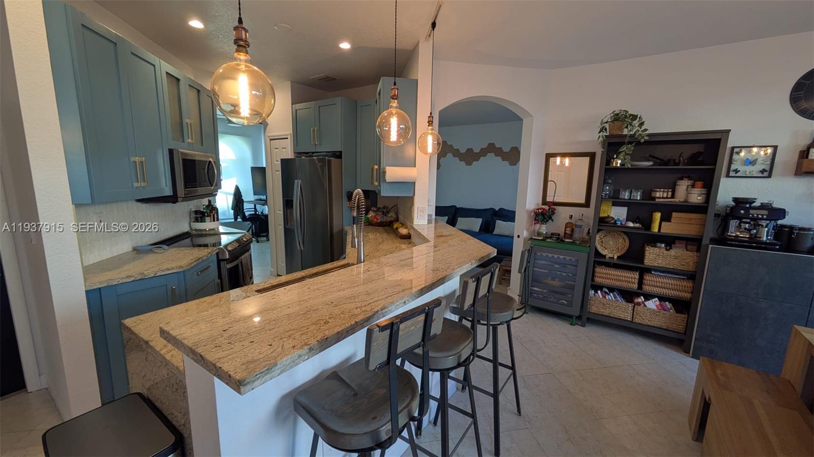 12293 Southwest 123rd Terrace Miami, FL 33186 - Photo 7 of 30 a kitchen with stainless steel appliances kitchen island granite countertop a table chairs in it and wooden floors