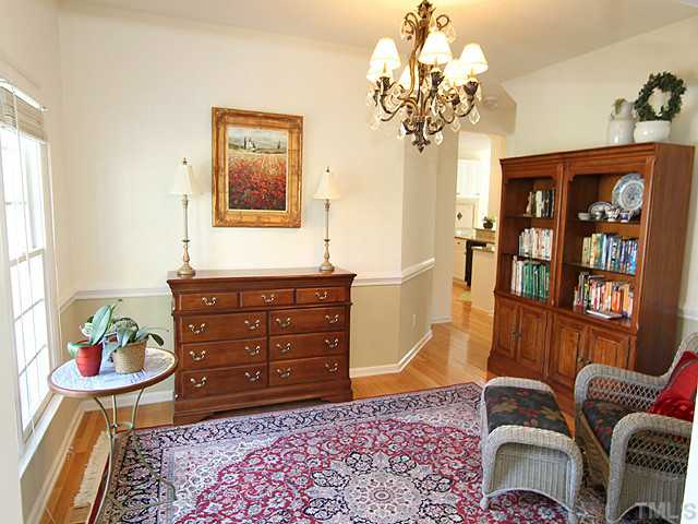 12308 Amoretto Way Raleigh, NC 27613 - Photo 5 of 13 Hardwood floors, chair railing and beautiful chandelier are the features of this separate dining room.
