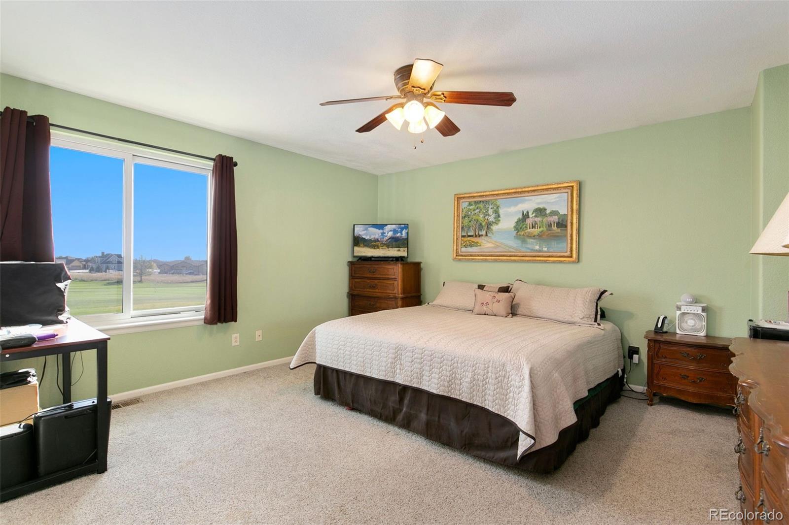 1606 Conestoga Drive Fort Lupton, CO 80621 - Photo 12 of 25 a bedroom with a bed and a chandelier
