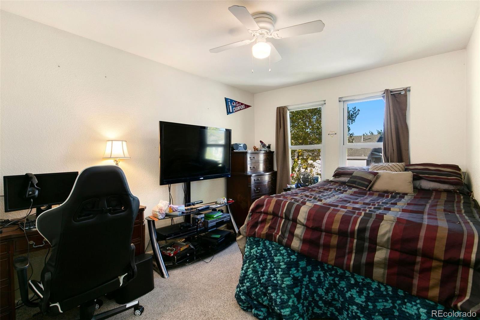 1606 Conestoga Drive Fort Lupton, CO 80621 - Photo 16 of 25 a bedroom with a bed and a flat screen tv