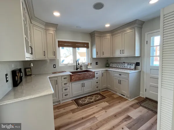 a dining room with furniture a chandelier and wooden floor