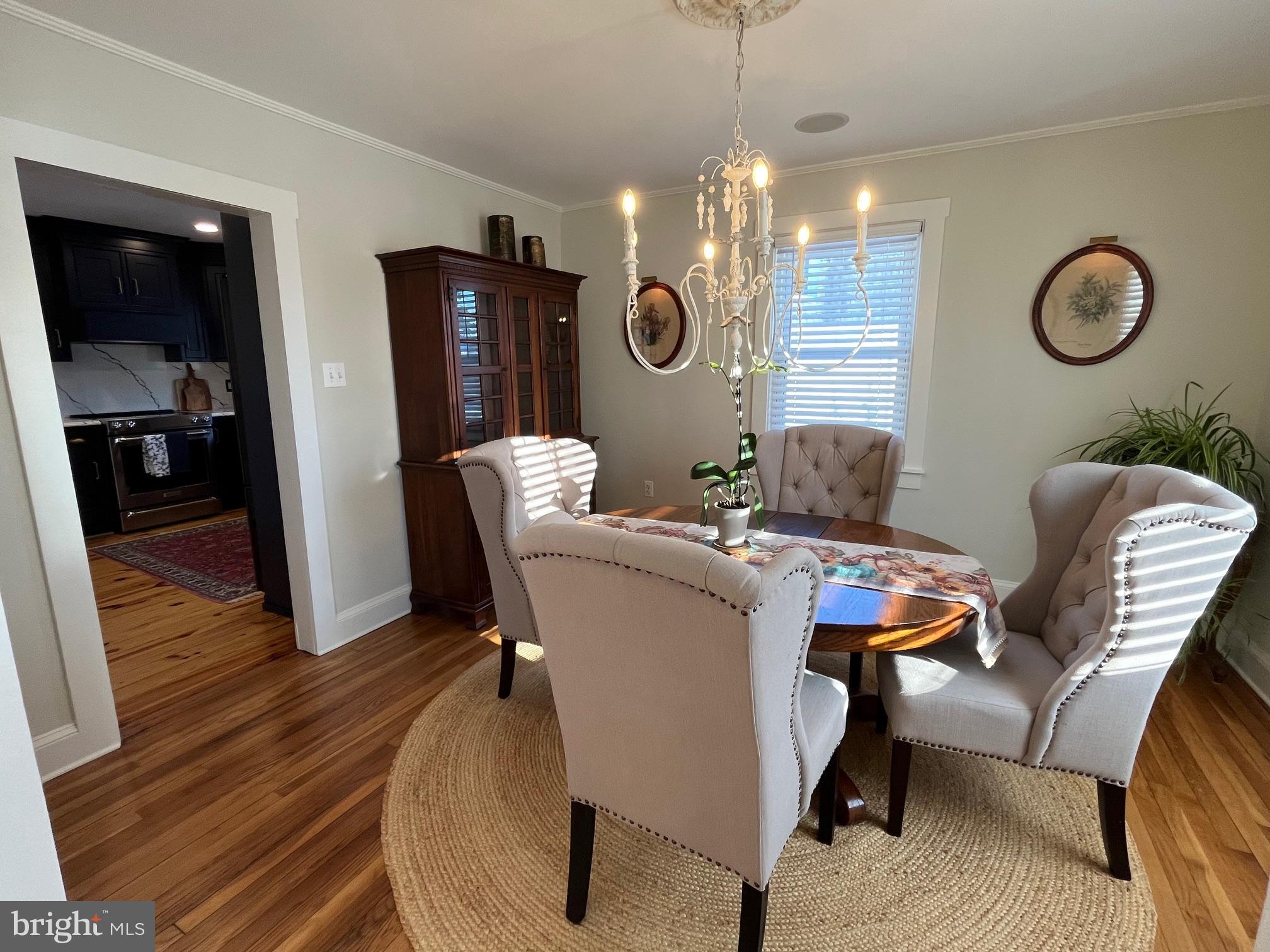 21560 Chicken Point Road Tilghman, MD 21671 - Photo 12 of 25 a dining room with furniture a chandelier and wooden floor