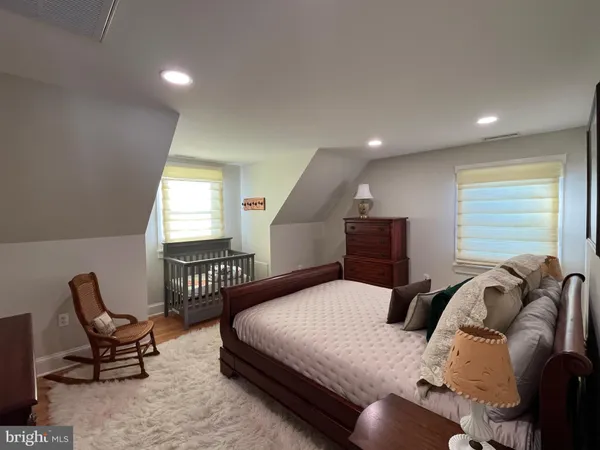 a hallway with white cabinets and wooden floor