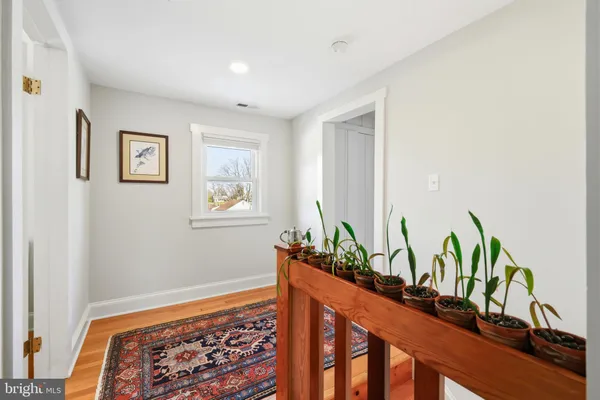 a dining room with wooden floor a chandelier a wooden table and chairs