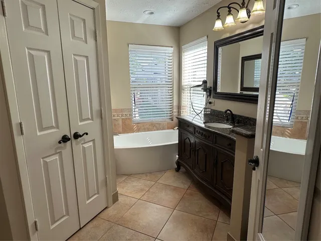 a bathroom with a double vanity sink a mirror and a bathtub