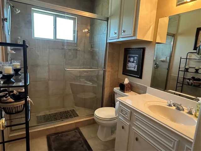 a bathroom with a sink a toilet and shower