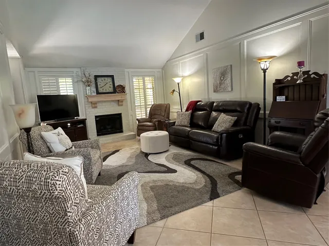 a living room with furniture a fireplace and a flat screen tv