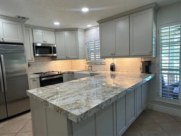 a kitchen with a stove a sink a microwave and refrigerator