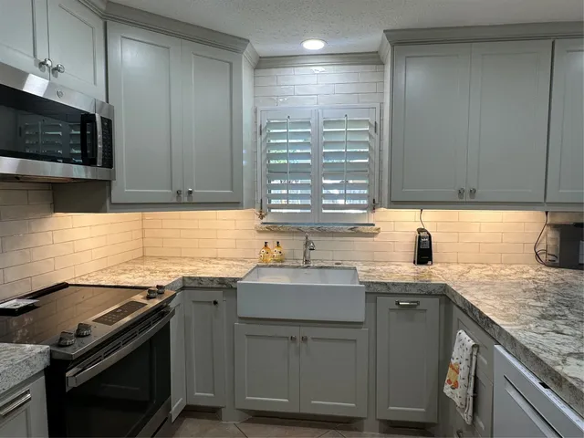 a kitchen with a sink stove top oven and cabinets