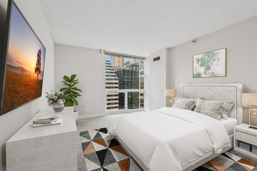 200 North Dearborn Street, Unit 2402 Chicago, IL 60601 - Photo 11 of 22 a bedroom with a bed and a flat screen tv
