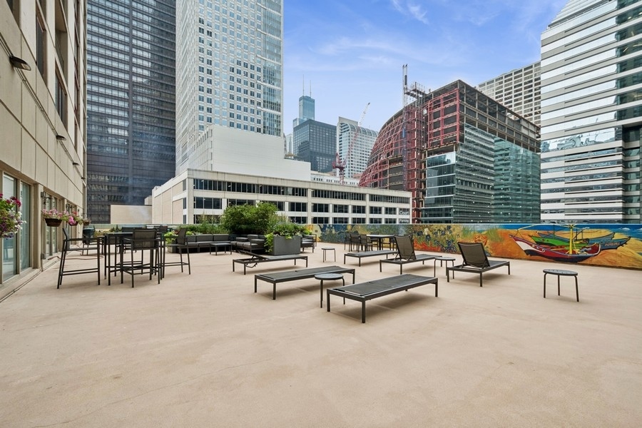 200 North Dearborn Street, Unit 2402 Chicago, IL 60601 - Photo 21 of 22 a roof deck with outdoor seating and city view