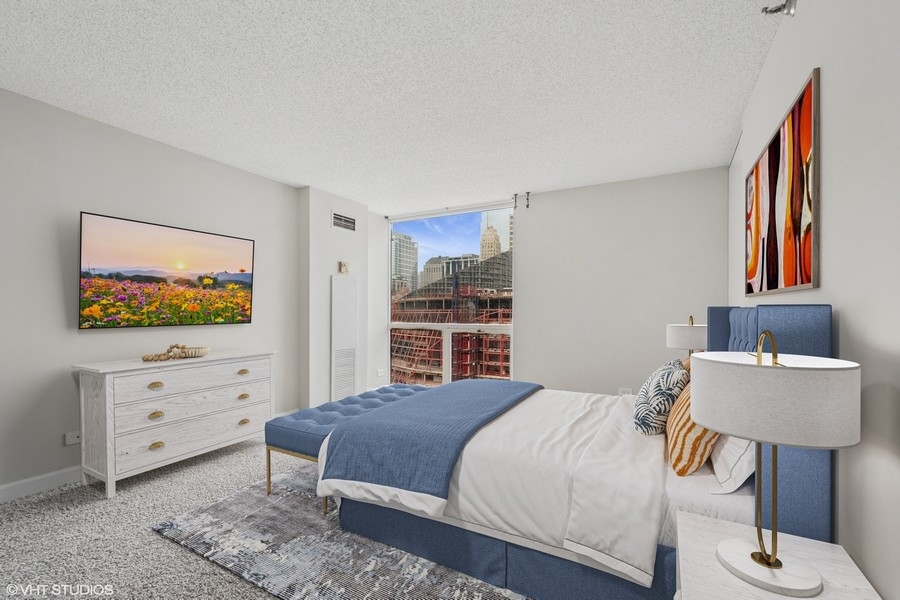 200 North Dearborn Street, Unit 2402 Chicago, IL 60601 - Photo 9 of 22 a bedroom with a bed and a flat screen tv