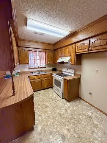 a kitchen with stainless steel appliances granite countertop a stove a sink dishwasher and a refrigerator
